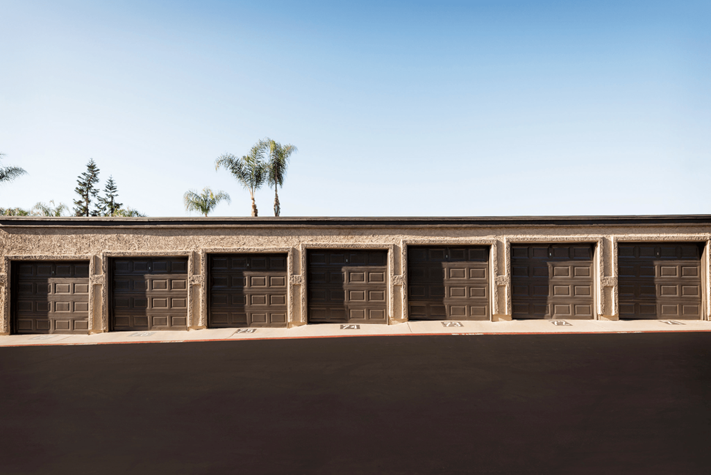 a row of garages with palm trees in the background