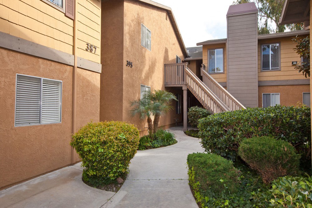 a sidewalk in front of a building with a staircase