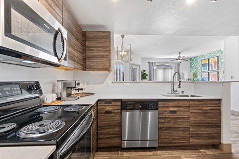 A modern kitchen with a stainless steel stove and a wooden cabinet.