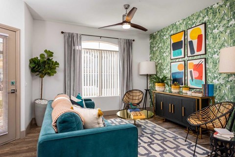 A living room with a blue couch and a green plant.