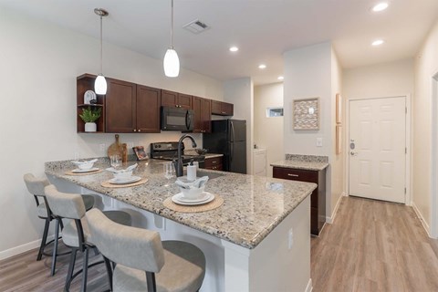 A kitchen with granite countertops and a breakfast bar.