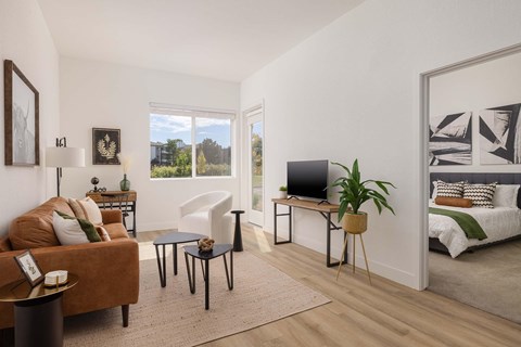 A living room with a brown sofa, a black table, and a white chair.