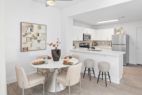 A modern dining room with a white table and chairs.