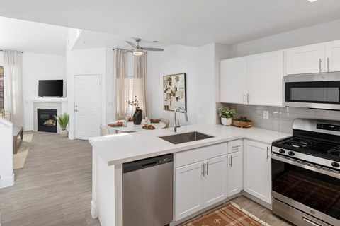 A modern kitchen with white cabinets and stainless steel appliances.