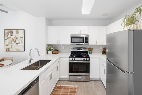 A modern kitchen with stainless steel appliances and white cabinets.
