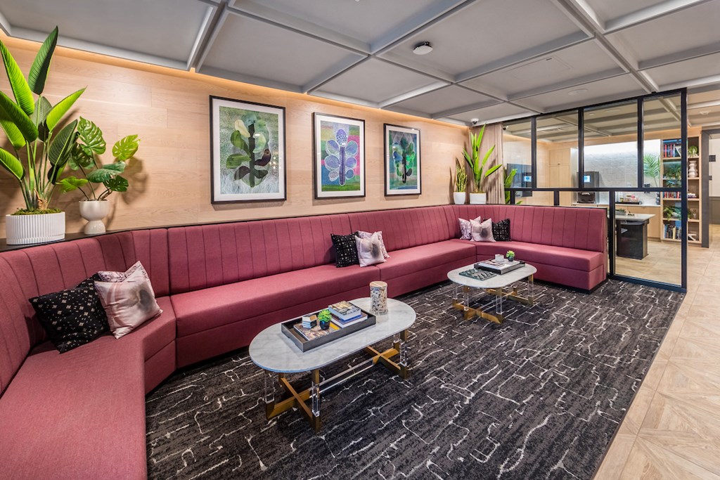 Community rideshare lounge with long wraparound couch and tables