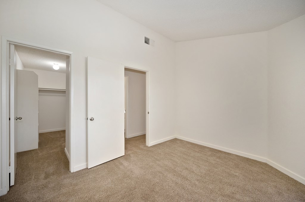 Bedroom interior with large closets and high ceilings