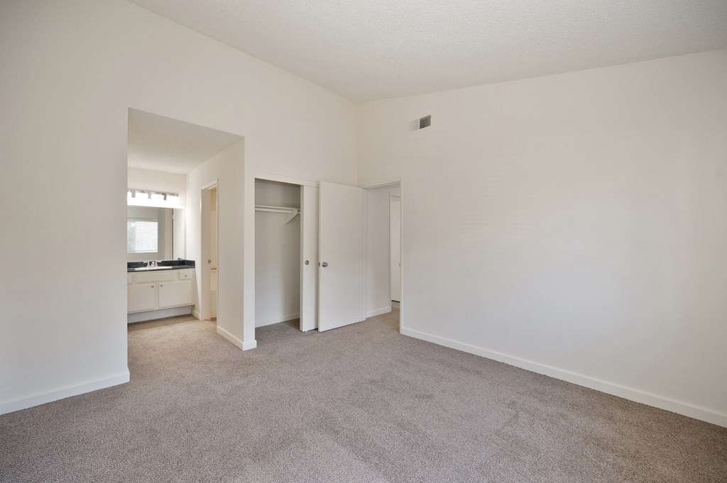 Bedroom with vanity area and vaulted ceiling
