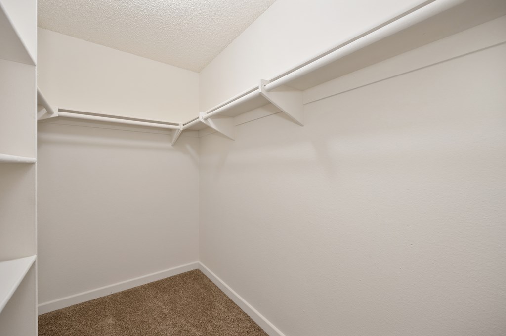 Large closet interior with shelving and hanging rails