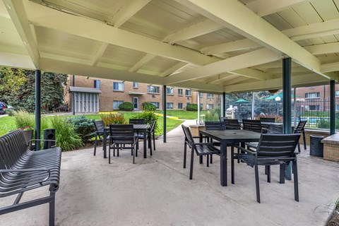A patio with a table and chairs under a white canopy.