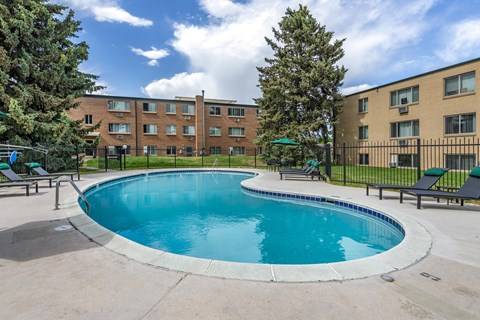 A swimming pool in front of apartment buildings.