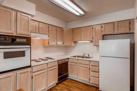 A kitchen with wooden cabinets and a white refrigerator.