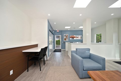The interior of the clubhouse with the washer and dryers, a couch and coffee table, and a vending machine.