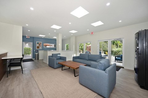 A spacious living room with a grey sofa set and a wooden coffee table.