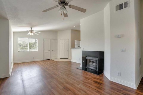 A living room with a fireplace and a ceiling fan.