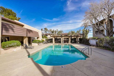A swimming pool in a residential area surrounded by a fence.