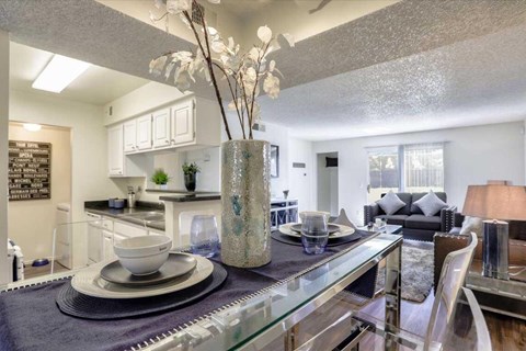 A modern dining room with a glass table and chairs.