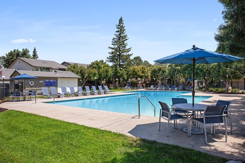 The pool area at Stonegate Apartments with lounge chairs surrounding.