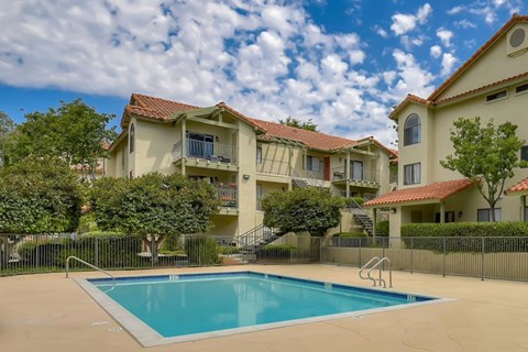 A swimming pool in front of a row of houses.
