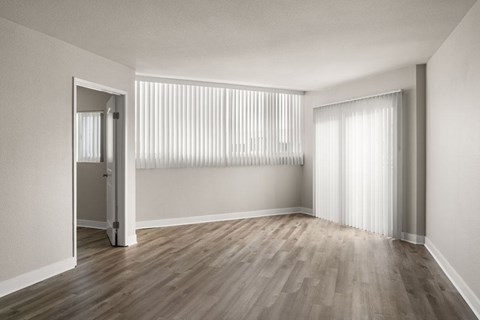 A room with wooden flooring and white walls.