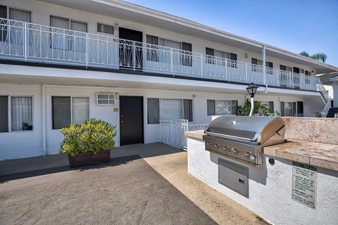 Exterior of the community's courtyard with a grill and counter space.
