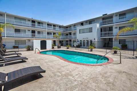 Swimming pool with lounge chairs surronding.