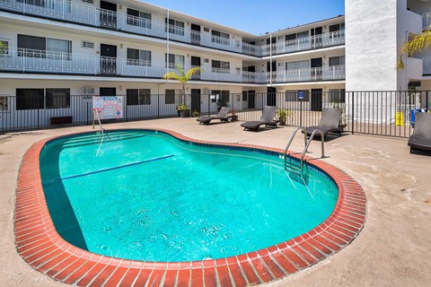 Swimming pool with lounge chairs surronding.