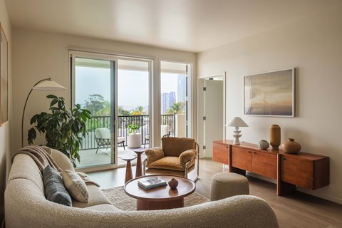 A living room with a couch, a chair, a table, and a painting on the wall.