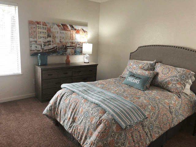 a bedroom with a bed and a painting on the wall