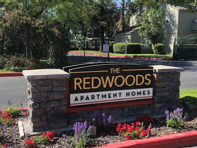 a sign for the redwoods apartments apartment homes