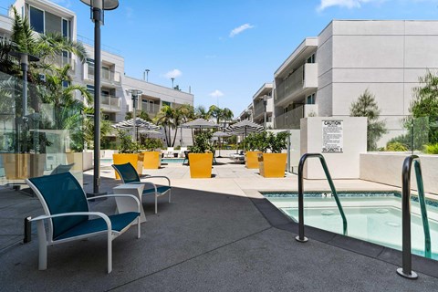 The pool area jacuzzi with 2 lounge chairs surrounding for relaxation