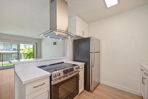 A kitchen with a stove top oven and a refrigerator.