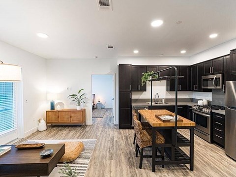 A modern kitchen with a dining table and chairs in the foreground.