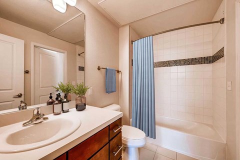 A bathroom with a white sink, toilet, and bathtub.