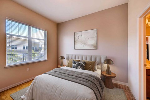 A bedroom with a large bed and a painting on the wall.