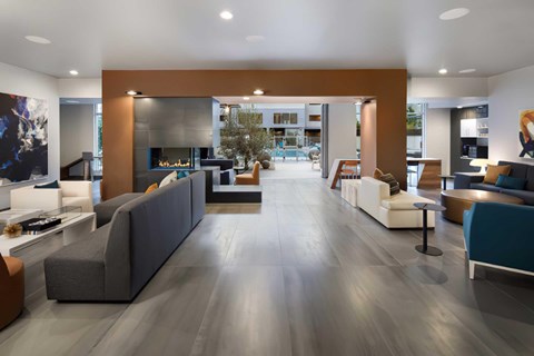 A modern clubhouse area with couches and an indoor fireplace.