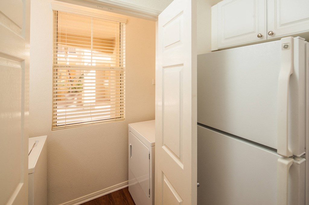 a small kitchen with a refrigerator and a window