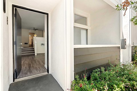The entrance of the apartment with the patio and the front door open.