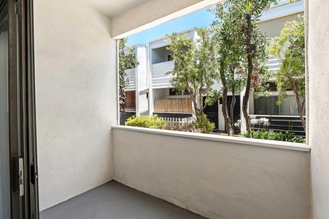 A balcony with a view of a building and trees.