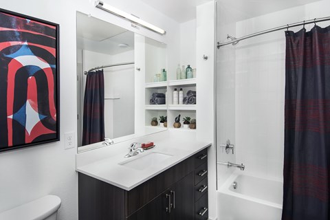 A bathroom with a white sink and mirror.