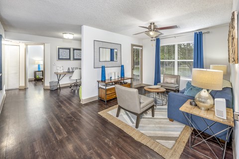 A living room with a blue couch and a wooden floor.