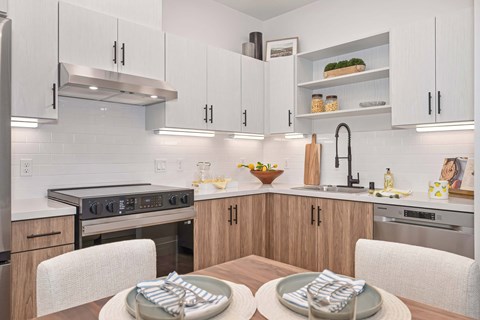 Kitchen with quartz counters, two-tone cabinets, and stainless steel appliances.