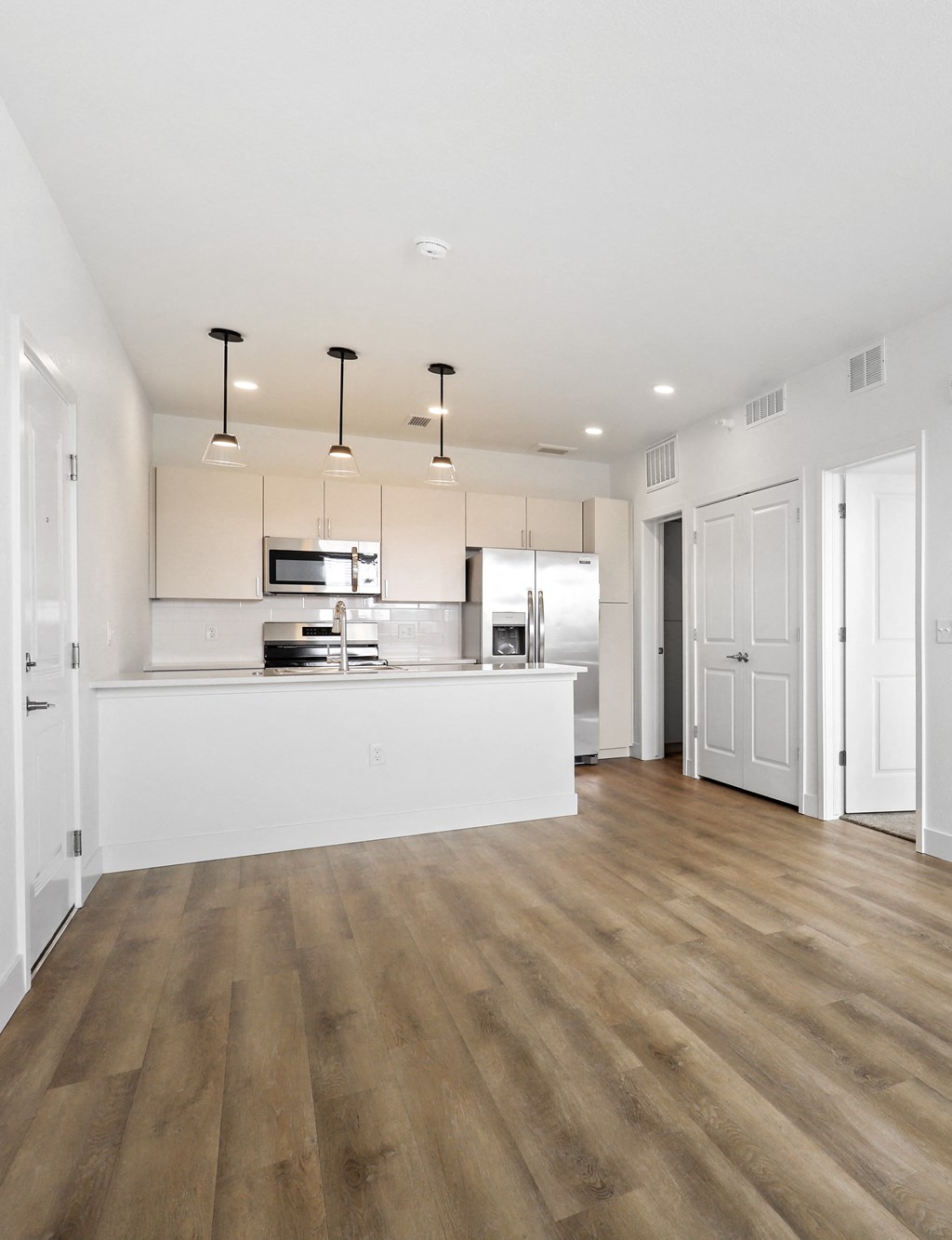 Empty kitchen connected to an empty living room