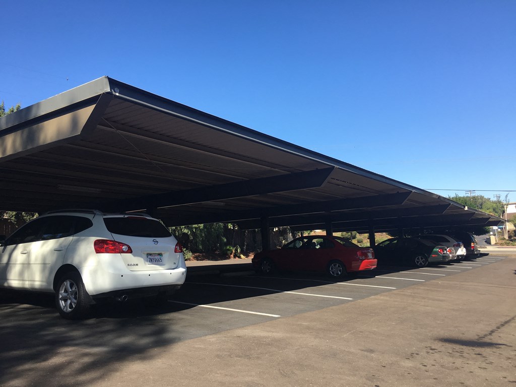 awning over a parking lot with cars parked under it