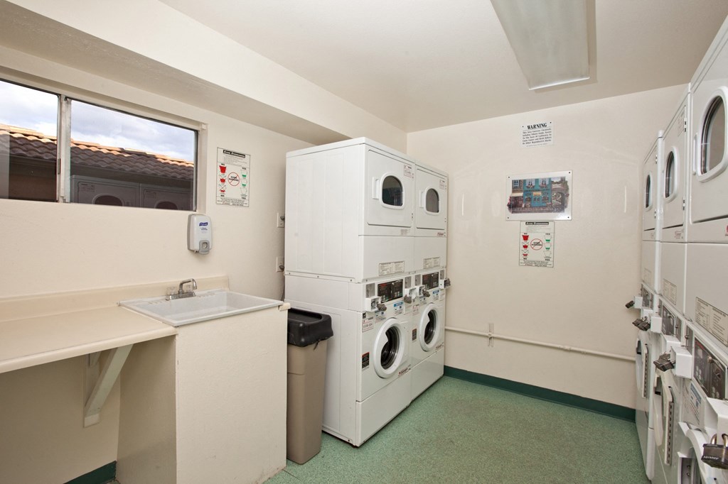 a utility room with washing machines and a sink