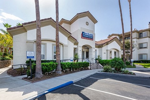a large white leasing office building with a blue sign on the front of it