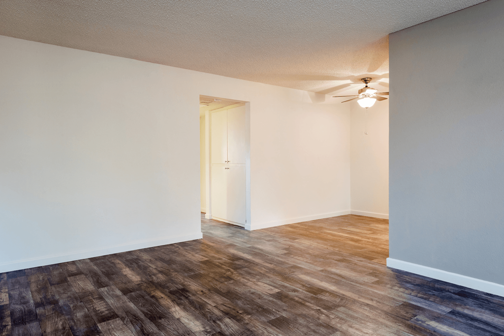 a bedroom with hardwood floors and white walls
