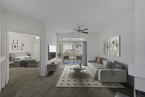 Carpeted living room with view to bedroom and patio with sliding glass door.