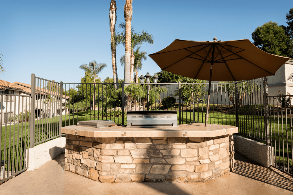 a fire pit with an umbrella in a backyard