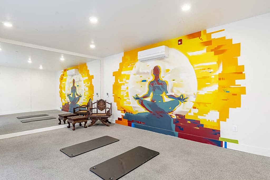 a room with a mural on the wall and yoga mats on the floor